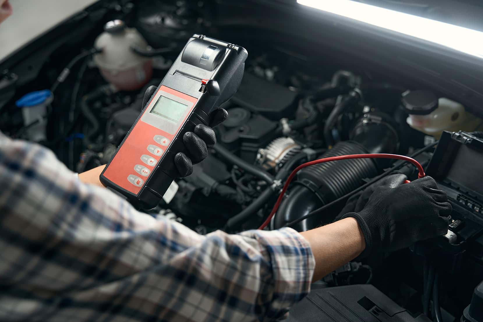 Procedure of computer diagnostics of a car in a car repair shop, a repairwoman in protective gloves